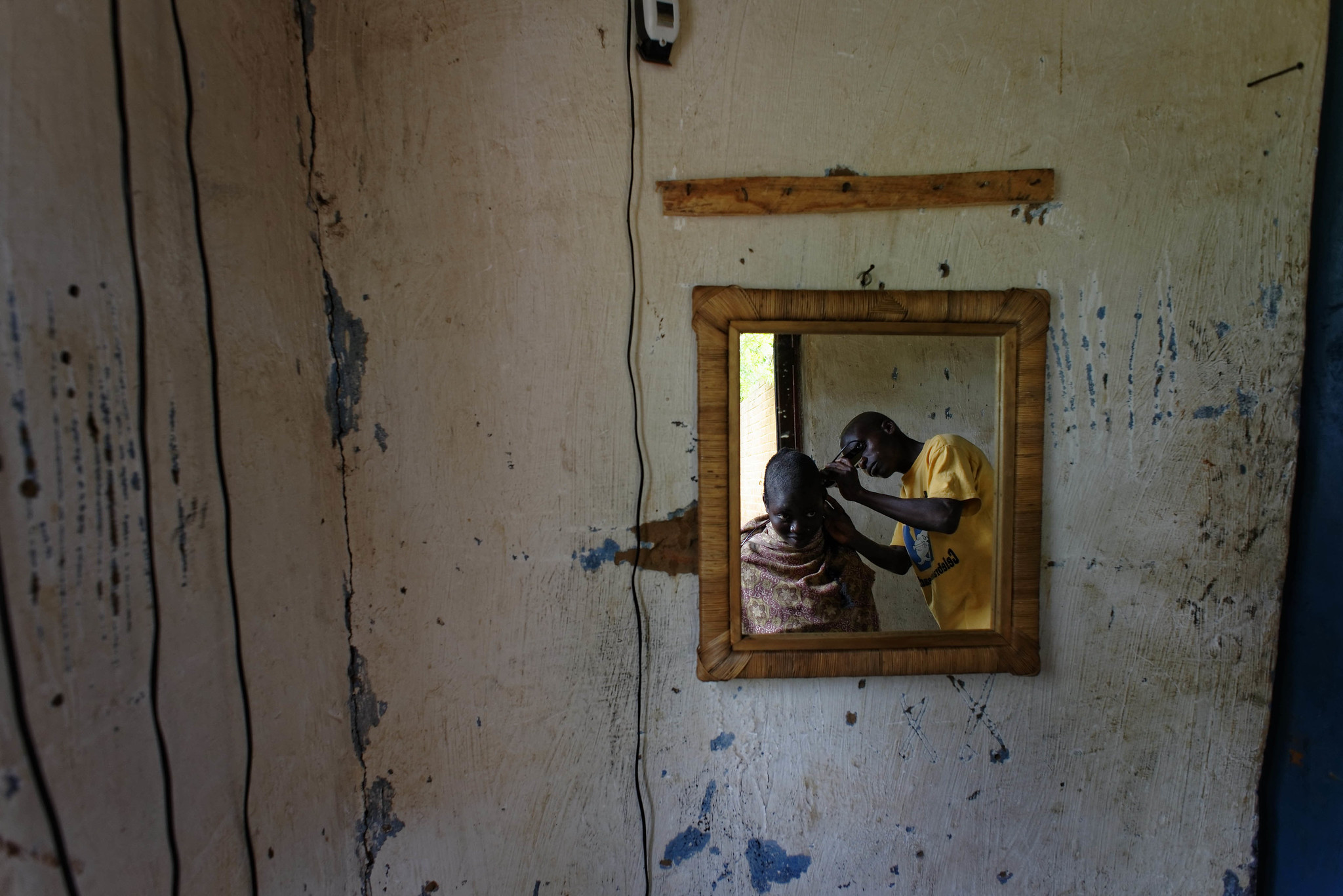 This young hairdresser above was pictured in the Kasungu region, Malawi. He uses a hair clipper powered by a solar panel offered by the ILO